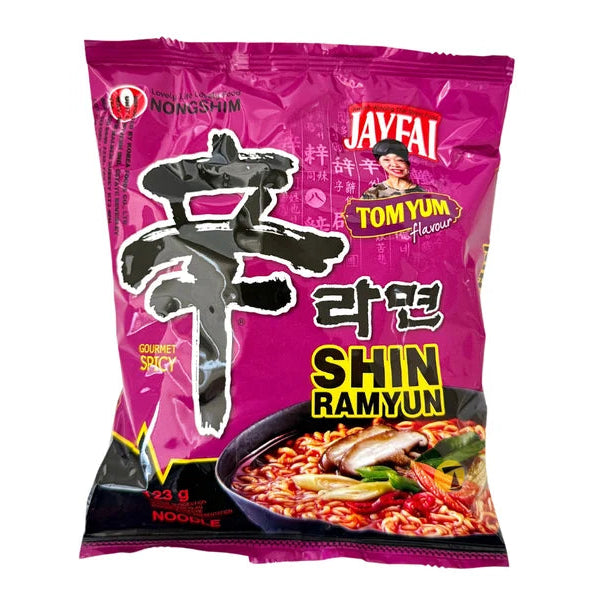 A package of Javeai Tomyun Shin Ramyun instant noodles on a plain white background. The packaging is predominantly magenta pink with black, yellow, and white text and graphics, and features a photo of the prepared noodle dish at the bottom.