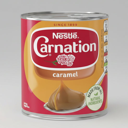 A can of Nestlé Carnation caramel sauce on a plain white background. The can features a red and golden-yellow label with a spoonful of brown caramel sauce and a green 'Made from all natural ingredients' badge.