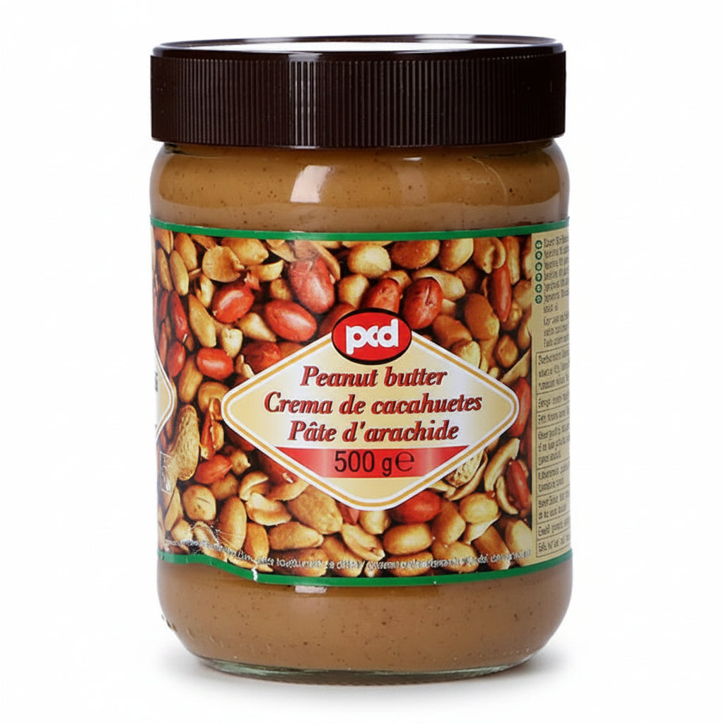 A 500g glass jar of Ptd Peanut Butter with a dark brown lid and a colorful label showing peanuts, containing smooth peanut butter.