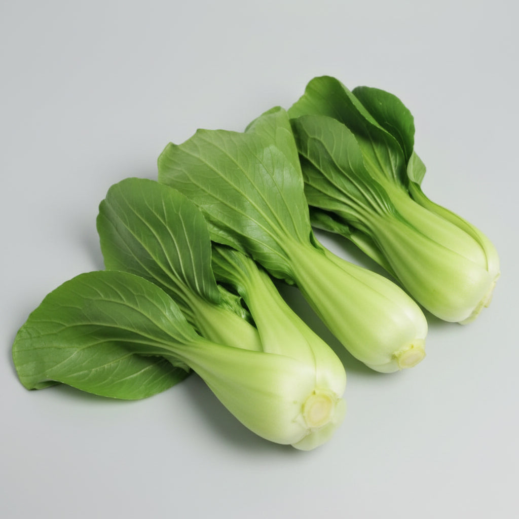 Four fresh green bok choy vegetables with light green to white stems, arranged on a plain white background.